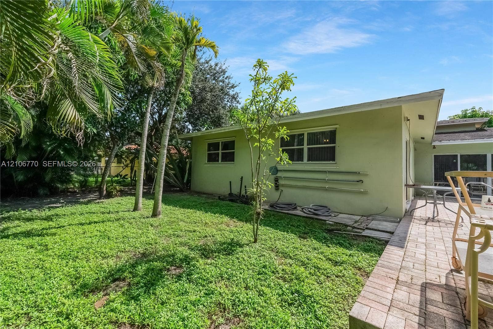 5701 SW 1st Street, Plantation, FL 33317 Exterior backyard space featuring a paver patio, established palm trees, and mature landscaping