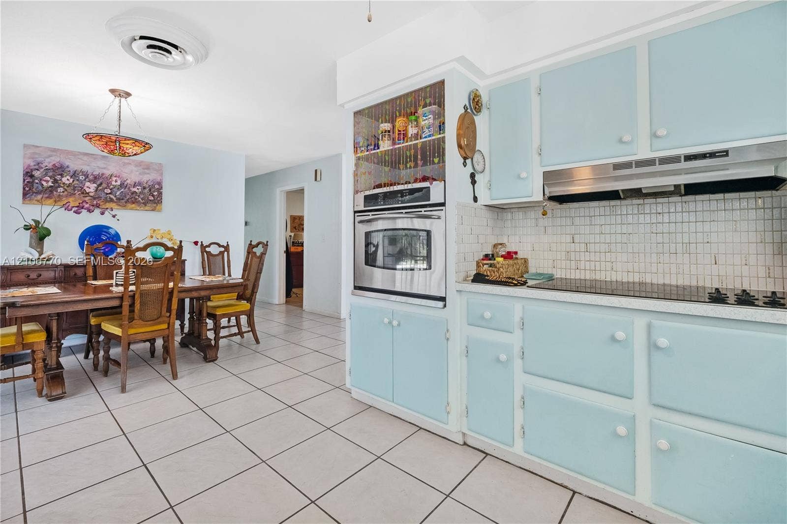 5701 SW 1st Street, Plantation, FL 33317 Kitchen featuring custom blue cabinetry, built-in stainless steel wall oven, ceramic tile backsplash, and ceramic tile flooring