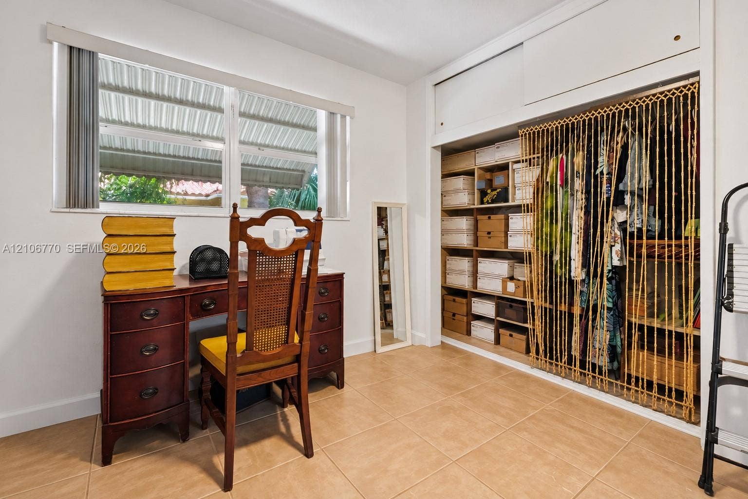 5701 SW 1st Street, Plantation, FL 33317 Neutral-toned tile flooring, horizontal sliding window, and built-in closet featuring upper storage cabinetry and partitioned shelving