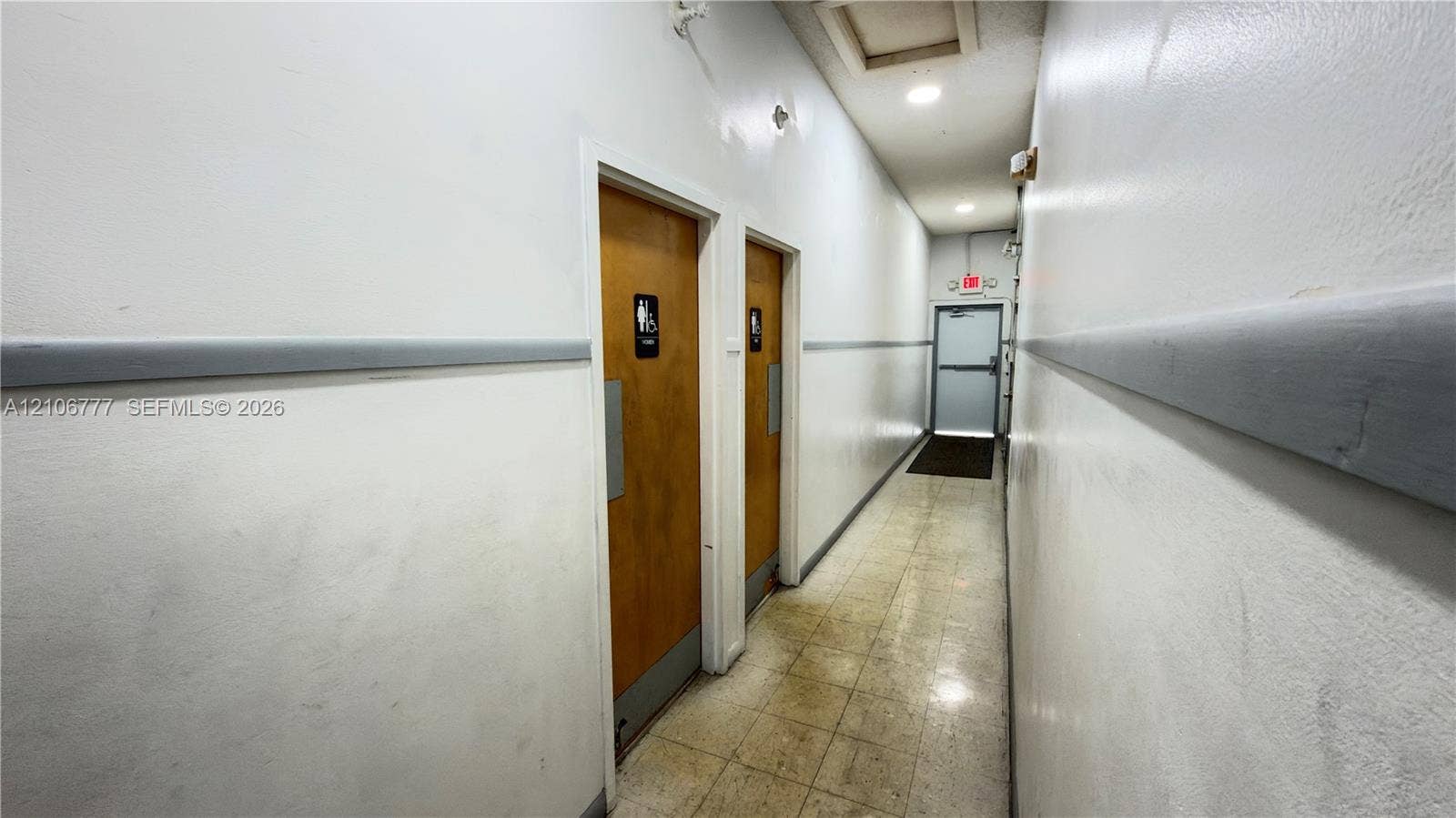 1810 SW 81st Avenue, #2200, North Lauderdale, North Lauderdale, FL 33068 Hallway featuring recessed ceiling lighting, two wood-finish doors with metal push plates, and a metal-frame emergency exit door