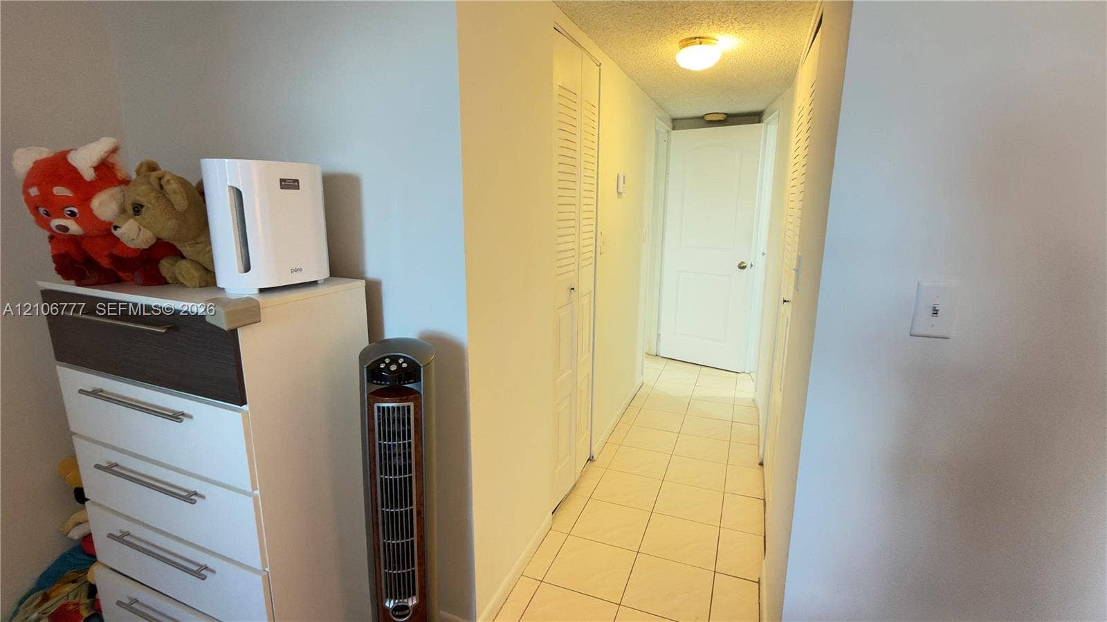 1810 SW 81st Avenue, #2200, North Lauderdale, North Lauderdale, FL 33068 Interior hallway featuring tile flooring, ceiling-mounted lighting, and two sets of louvered bifold closet doors