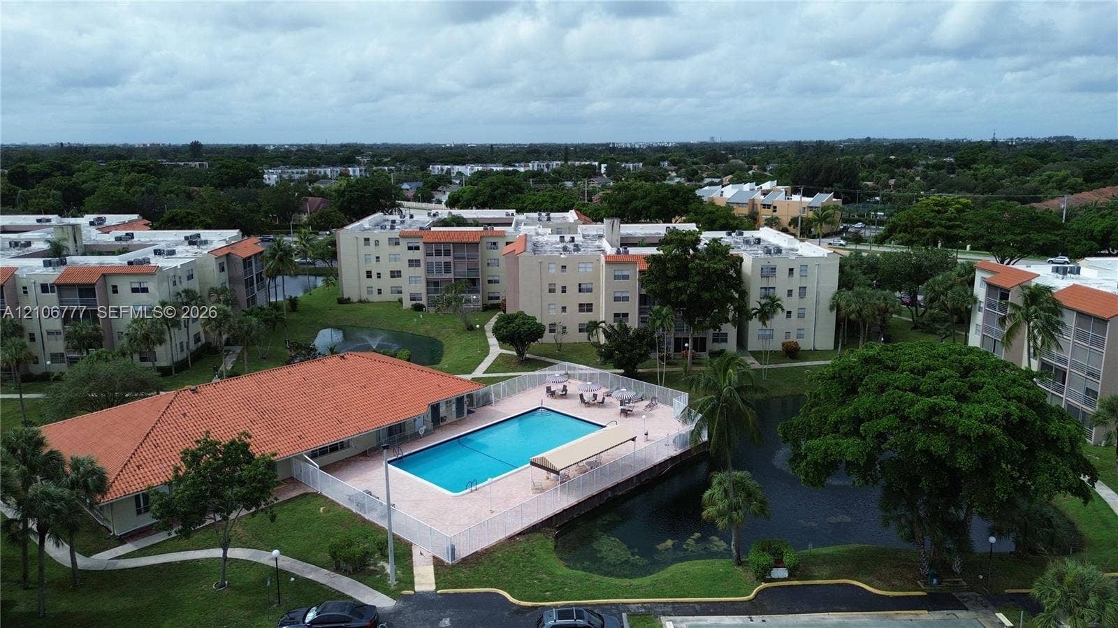 1810 SW 81st Avenue, #2200, North Lauderdale, North Lauderdale, FL 33068 Community swimming pool featuring a concrete deck and enclosure, set within landscaped grounds containing a pond