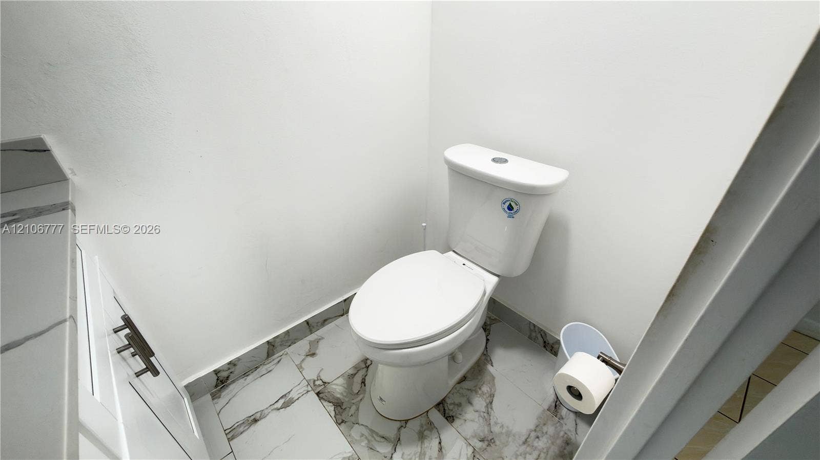 1810 SW 81st Avenue, #2200, North Lauderdale, North Lauderdale, FL 33068 Dual-flush toilet paired with stone-finish floor tiling featuring distinct veining, white cabinetry with dark metal hardware, and a matching stone-finish countertop