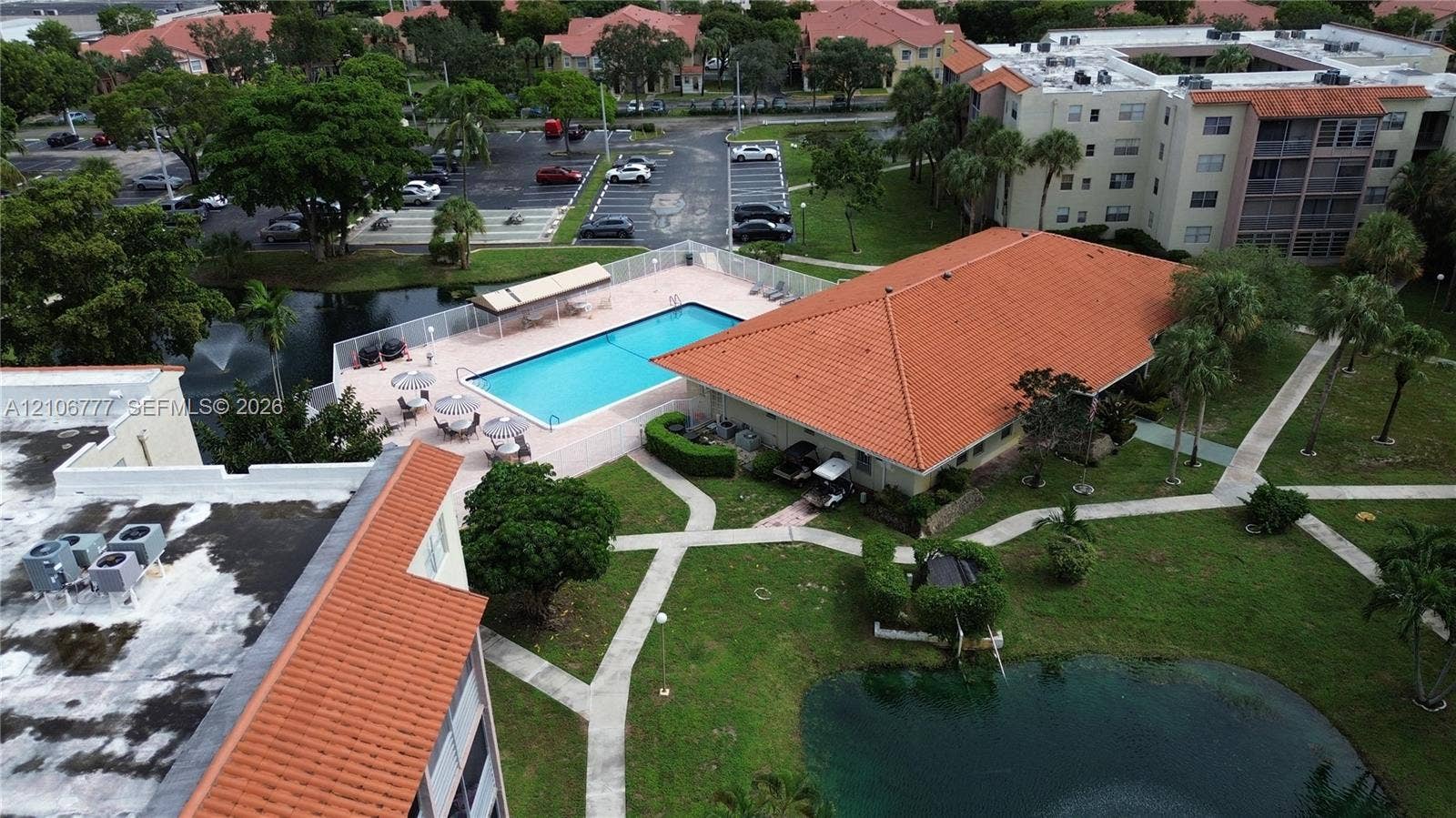 1810 SW 81st Avenue, #2200, North Lauderdale, North Lauderdale, FL 33068 Community swimming pool with a tiled deck, terracotta-style roof systems, landscaped grounds, and a water feature