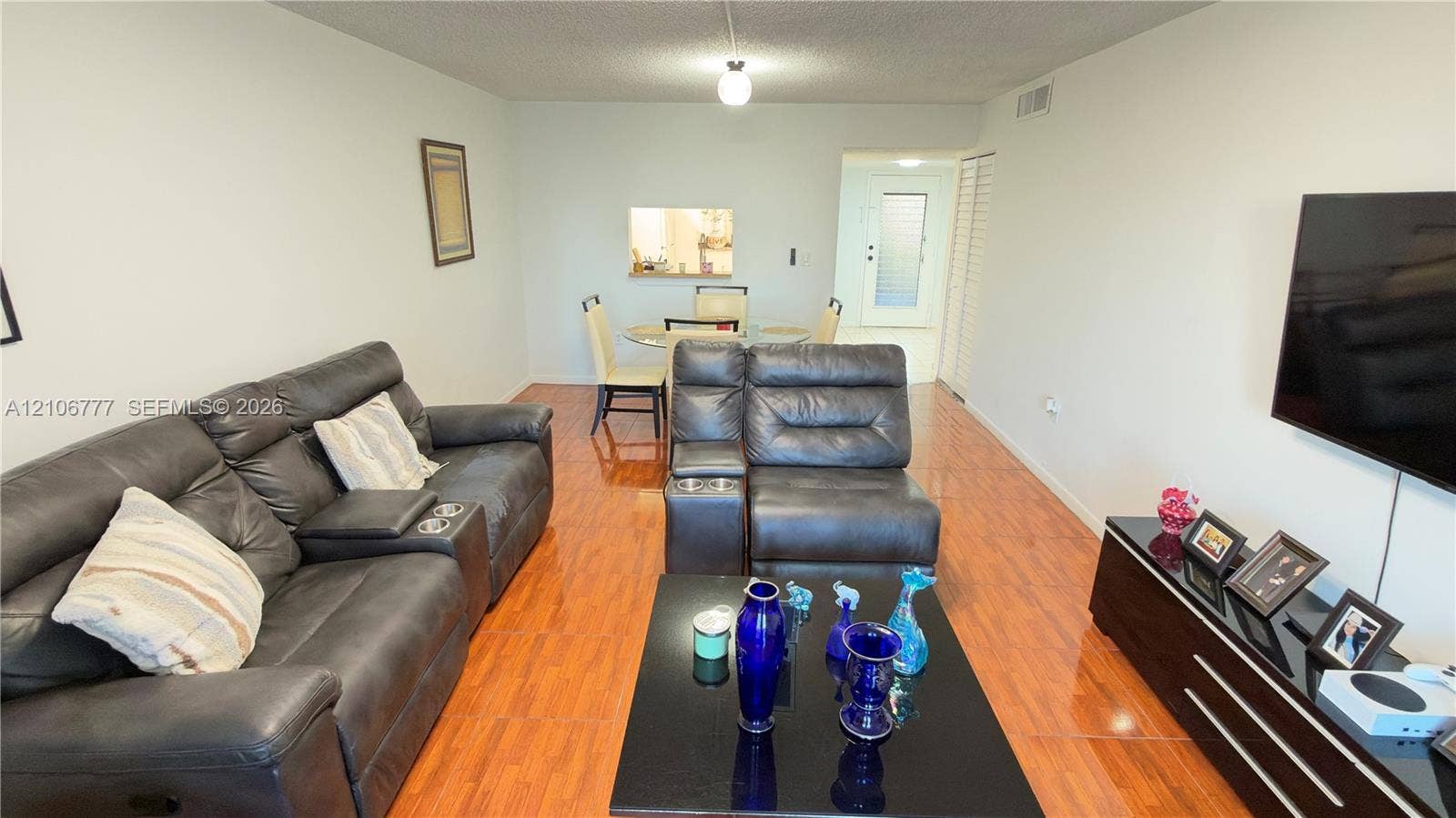 1810 SW 81st Avenue, #2200, North Lauderdale, North Lauderdale, FL 33068 Interior space featuring wood-finish flooring, textured ceiling, pass-through window opening, and louvered closet doors