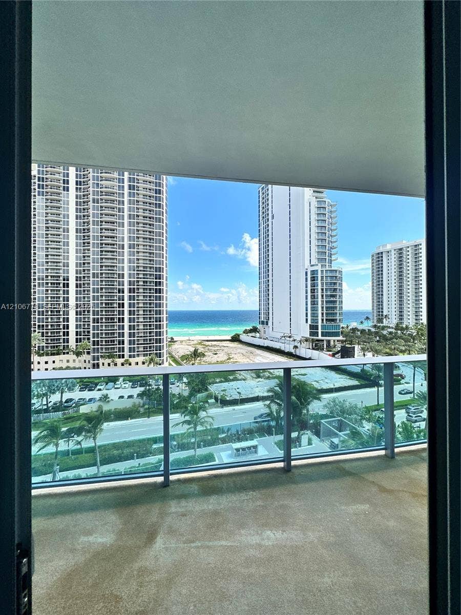 17550 Collins Avenue, #803, Sunny Isles Beach, Sunny Isles Beach, FL 33160 Concrete balcony with glass railing, offering ocean and urban scenery