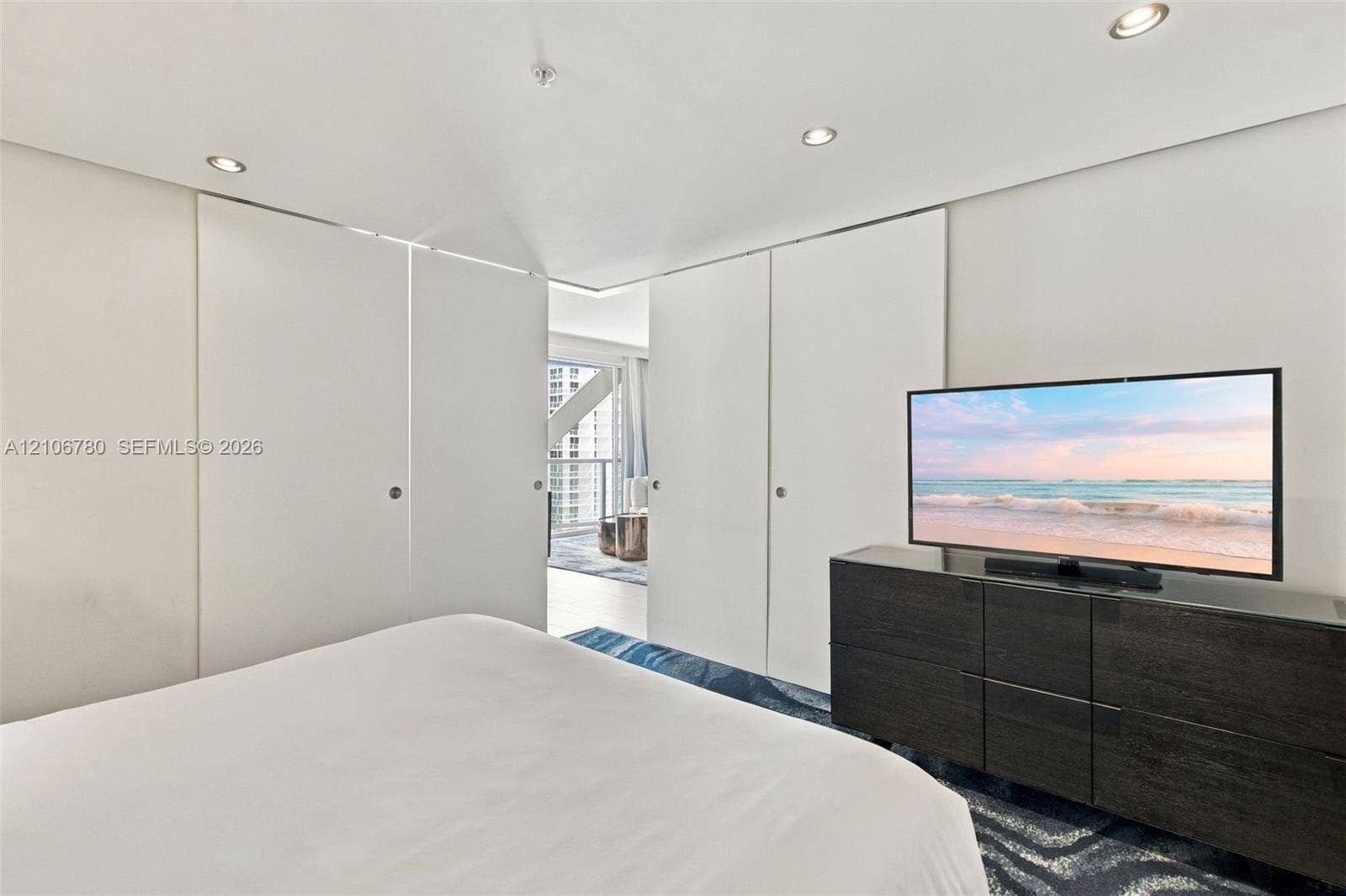 Floor-to-ceiling sliding panels, recessed lighting, and patterned floor covering