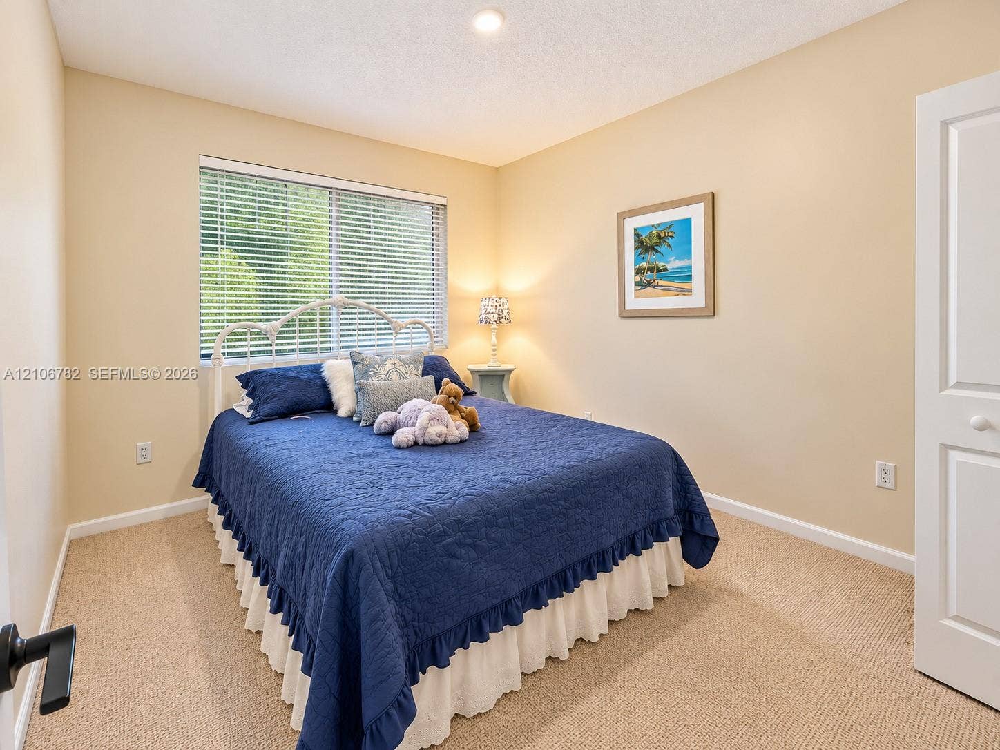 Neutral wall color, carpeted flooring, large window with horizontal blinds, recessed ceiling lighting, and a multi-panel door