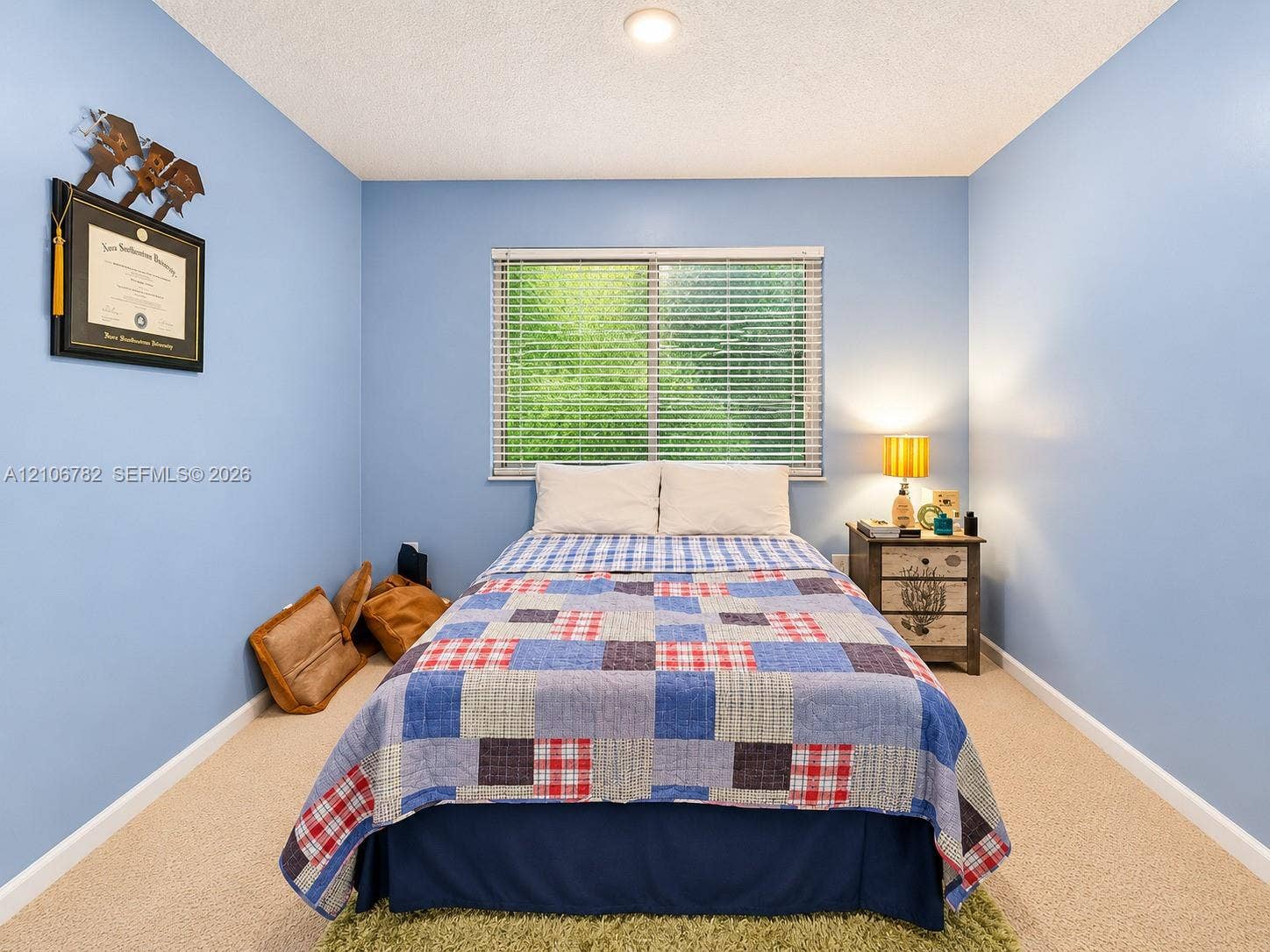 Bedroom with neutral carpeting, horizontal window blinds, and a central ceiling light fixture