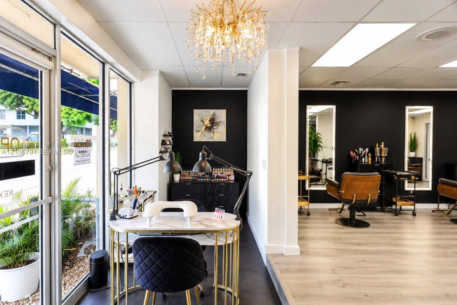 1684 SE 10th Avenue, Fort Lauderdale, Fort Lauderdale, FL 33316 Commercial interior featuring floor-to-ceiling glass windows, wood-finish flooring, decorative crystal chandelier, and wall-mounted backlit mirrors