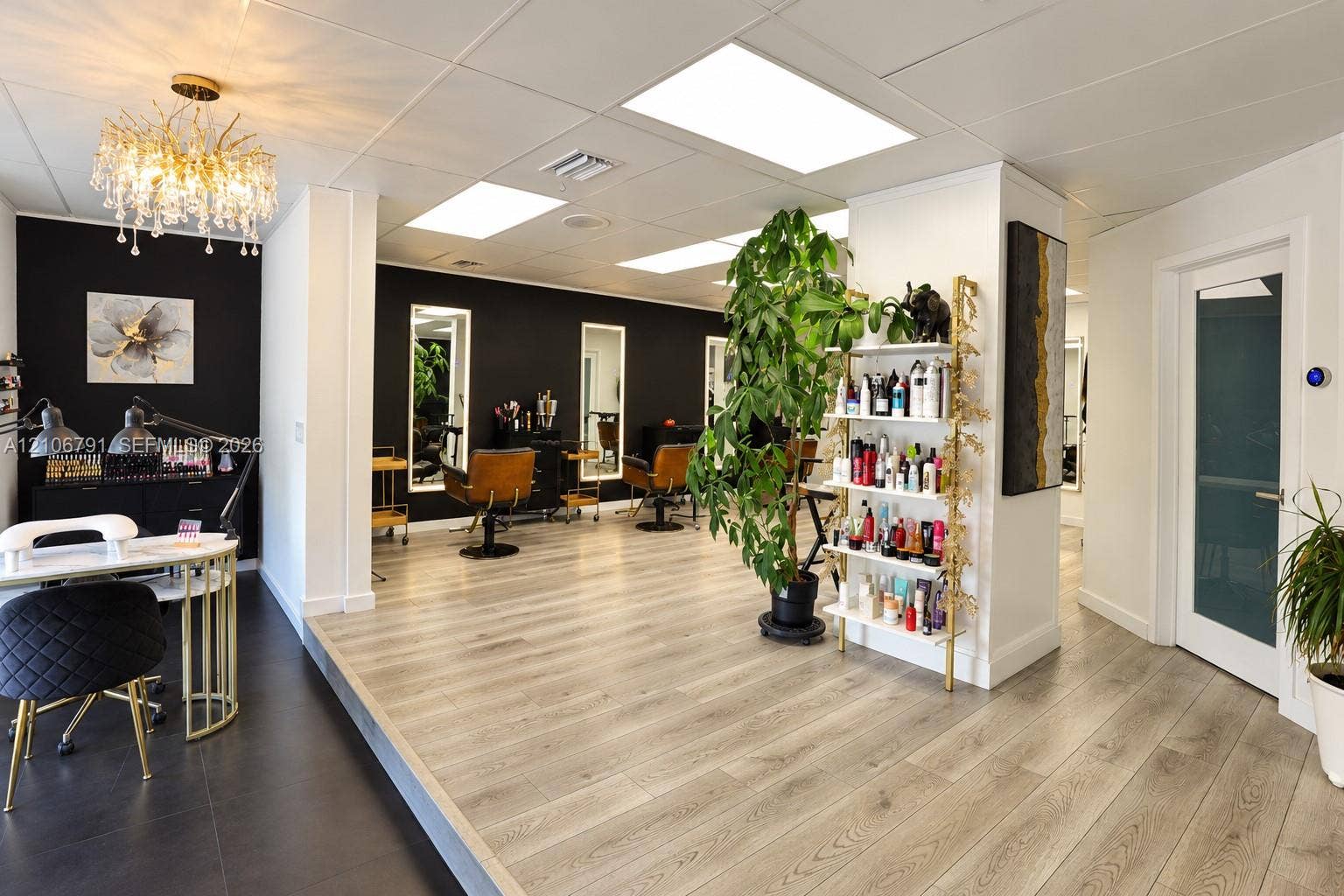 1684 SE 10th Avenue, Fort Lauderdale, Fort Lauderdale, FL 33316 Interior space featuring wood-finish flooring, recessed lighting, a decorative crystal-style chandelier, wall-mounted mirrors, and an accent wall with high-contrast paint finish