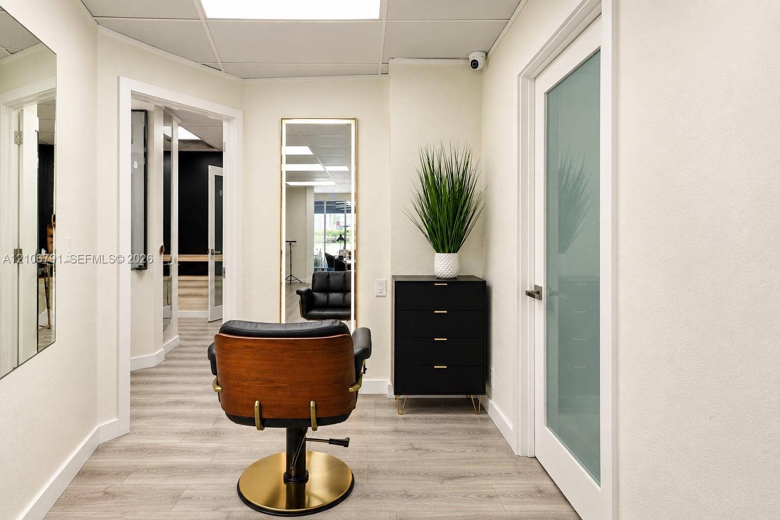 1684 SE 10th Avenue, Fort Lauderdale, Fort Lauderdale, FL 33316 Interior space featuring wood-finish flooring, a full-length wall-mounted mirror with integrated perimeter lighting, and doors with frosted glass inserts