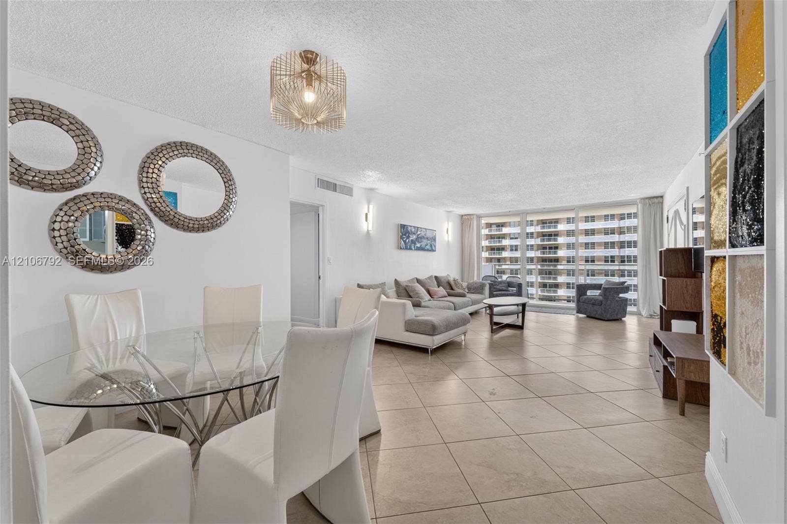 2030 S Ocean Drive, #723, Hallandale Beach, FL 33009 Open-concept floor plan featuring large-format ceramic tile flooring, floor-to-ceiling windows, and decorative multi-panel wall accent