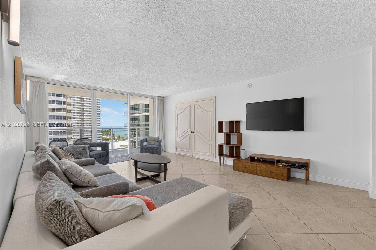 2030 S Ocean Drive, #723, Hallandale Beach, FL 33009 Large-format tile flooring, double interior doors with molded panel detailing, and floor-to-ceiling glass sliding doors opening to an exterior balcony