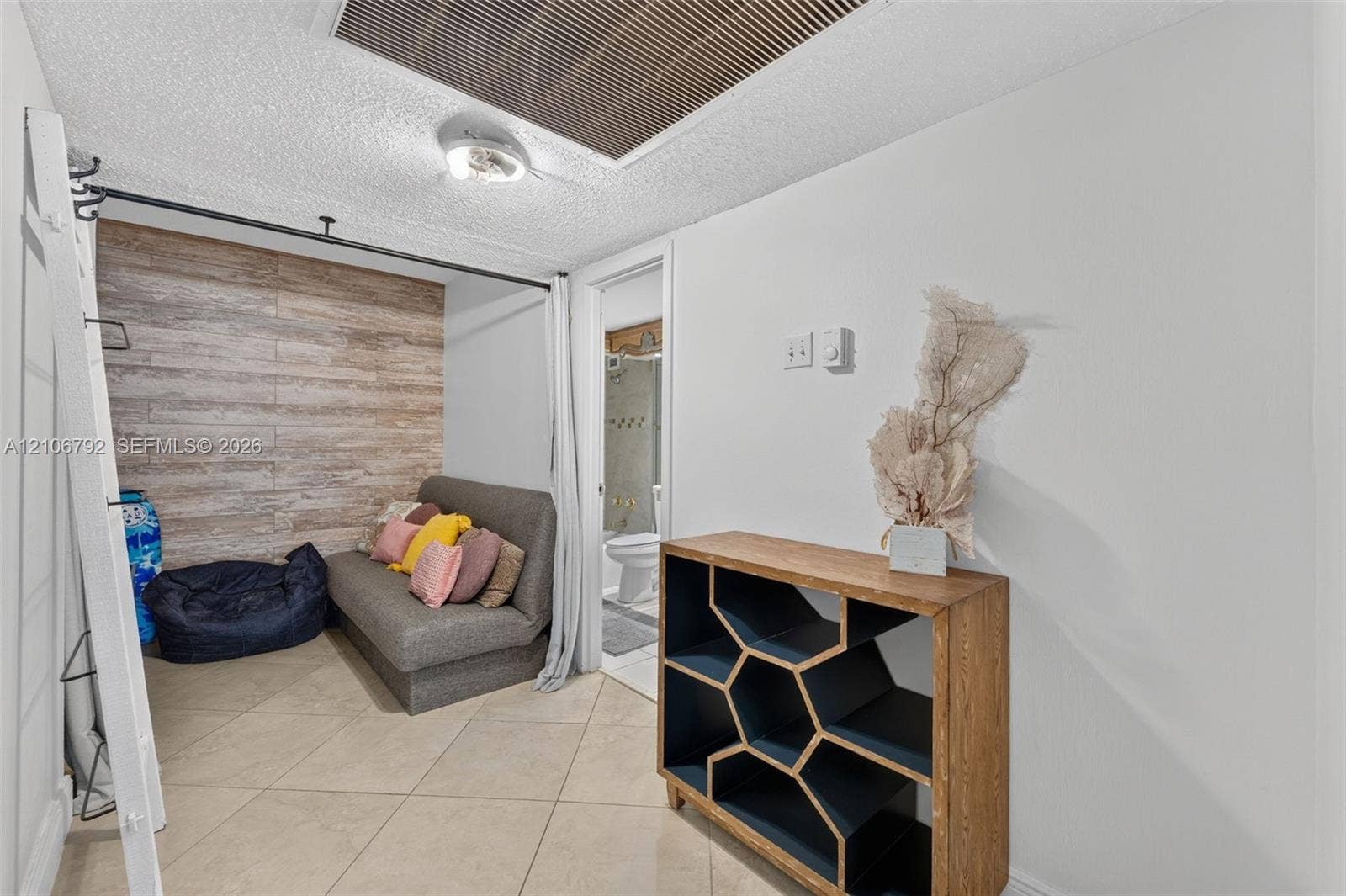 2030 S Ocean Drive, #723, Hallandale Beach, FL 33009 Room featuring large-format diagonal tile flooring, wood-finish wall paneling, and ceiling-mounted track hardware