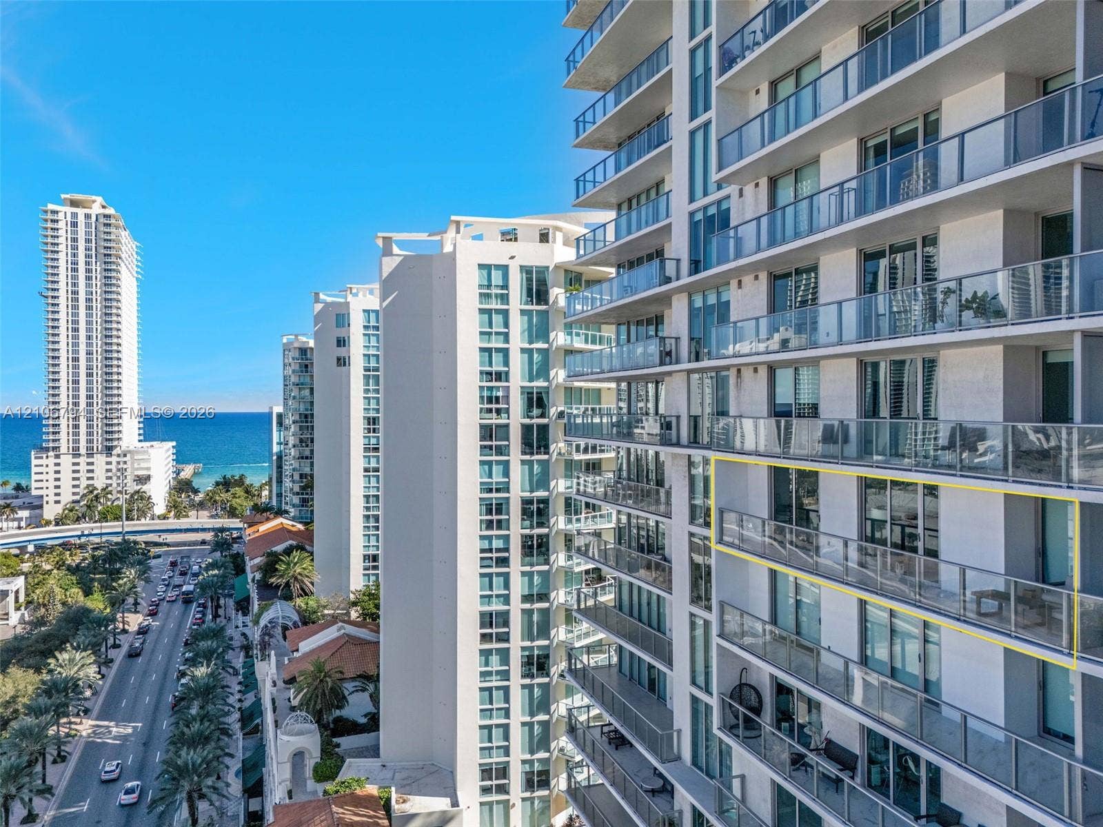 High-rise exterior featuring expansive glass-panel balconies, floor-to-ceiling windows, and direct exposure to coastal scenery