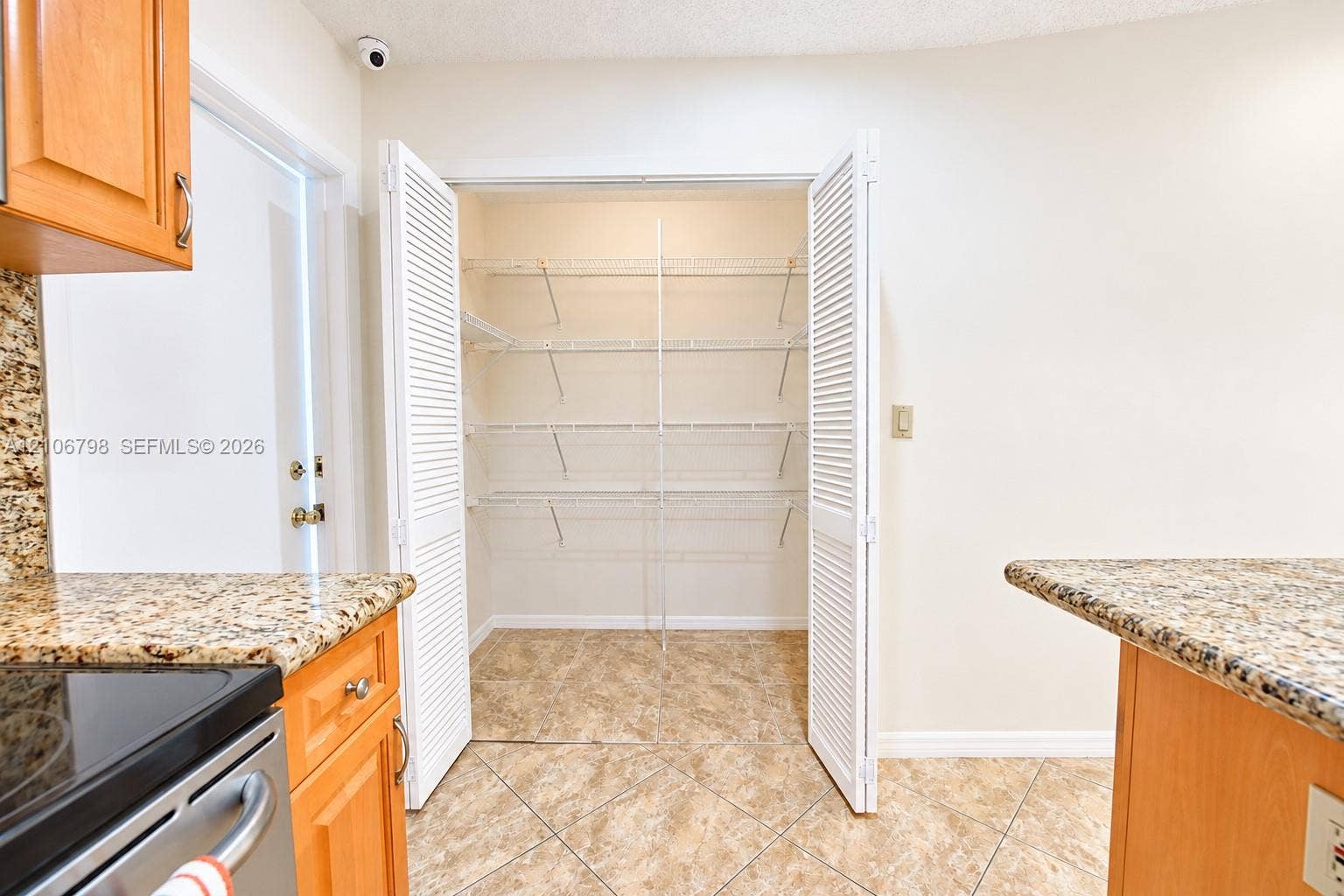 14750 SW 156th Street, Miami, FL 33187 Walk-in pantry featuring white louvered bifold doors and integrated multi-level wire shelving