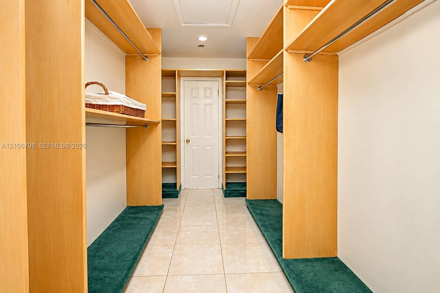 14750 SW 156th Street, Miami, FL 33187 Walk-in closet featuring custom light wood-finish shelving, integrated hanging rods, wall-to-wall carpeting on storage tiers, and tile flooring