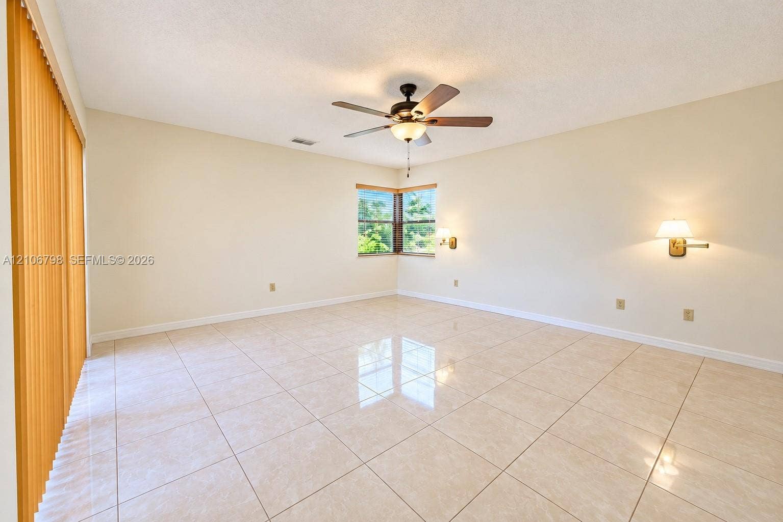 14750 SW 156th Street, Miami, FL 33187 Neutral-toned ceramic tile flooring, ceiling fan with light fixture, wall-mounted swing-arm sconces, corner windows, and vertical blinds