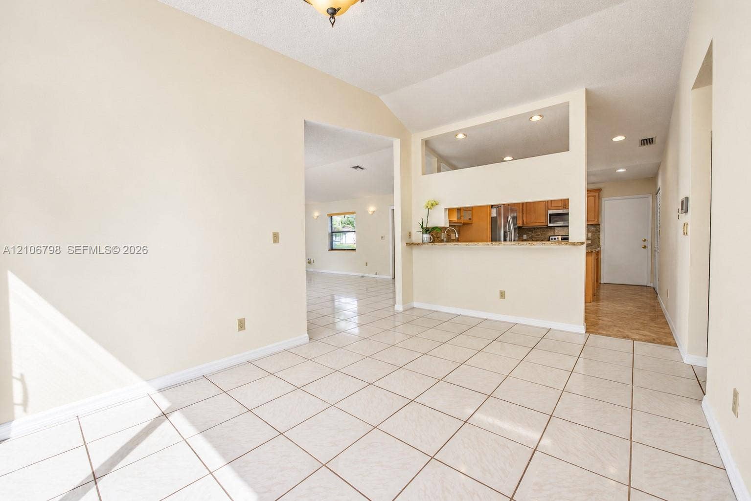 14750 SW 156th Street, Miami, FL 33187 Ceramic tile flooring throughout with vaulted ceilings, recessed lighting, and a breakfast bar pass-through
