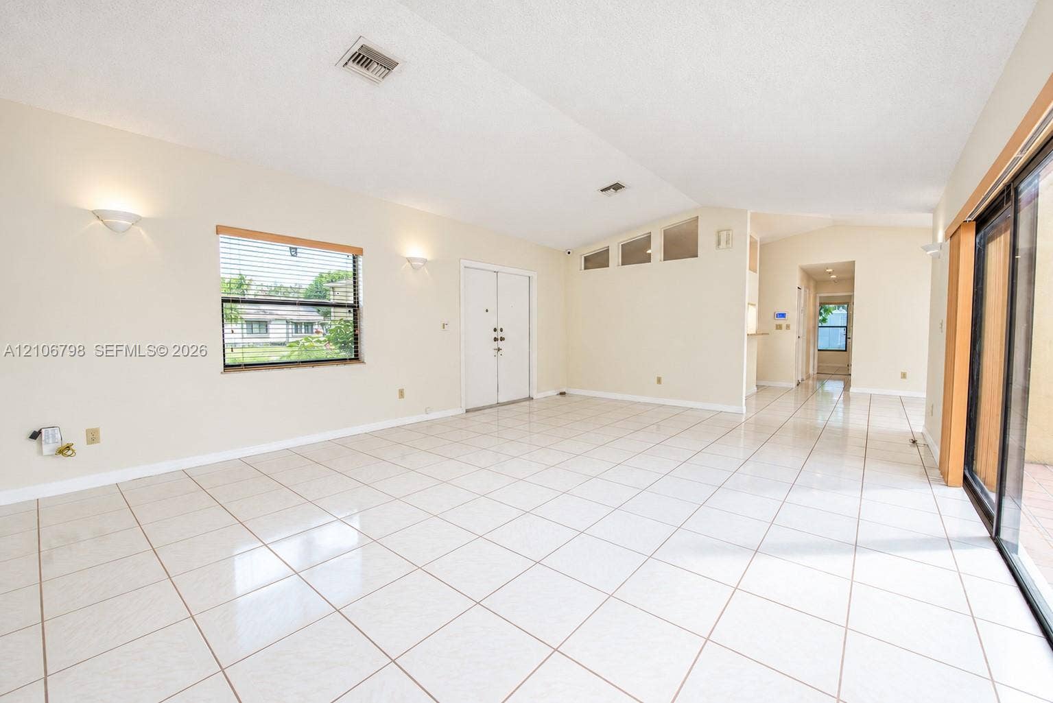 14750 SW 156th Street, Miami, FL 33187 Vaulted ceilings, large-format tile flooring, dual glass-paneled entry doors, transom windows, and sliding glass patio doors