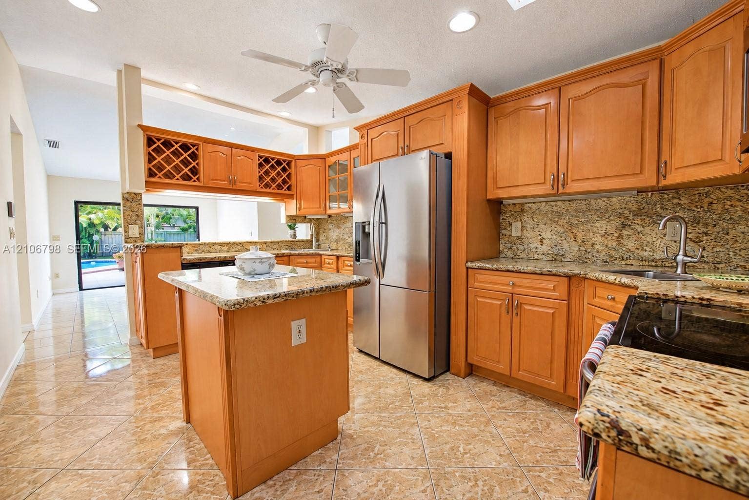 14750 SW 156th Street, Miami, FL 33187 Kitchen featuring wood cabinetry, stone countertops, a central island, stainless steel refrigerator, and recessed lighting