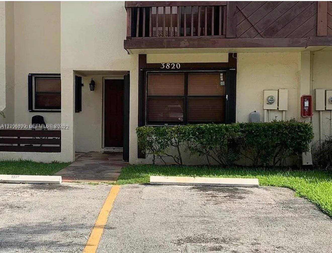 3820 SW 52nd Avenue, Hollywood, Hollywood, FL 33023 Exterior facade featuring a recessed entryway, private upper-level balcony with wood-tone railing, stone-paved walkway, and manicured hedge landscaping