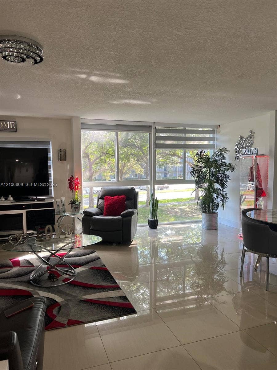 12600 SW 5th Court, #204L, Pembroke Pines, FL 33027 Large format polished tile flooring, expansive floor-to-ceiling windows, and recessed circular ceiling light fixture