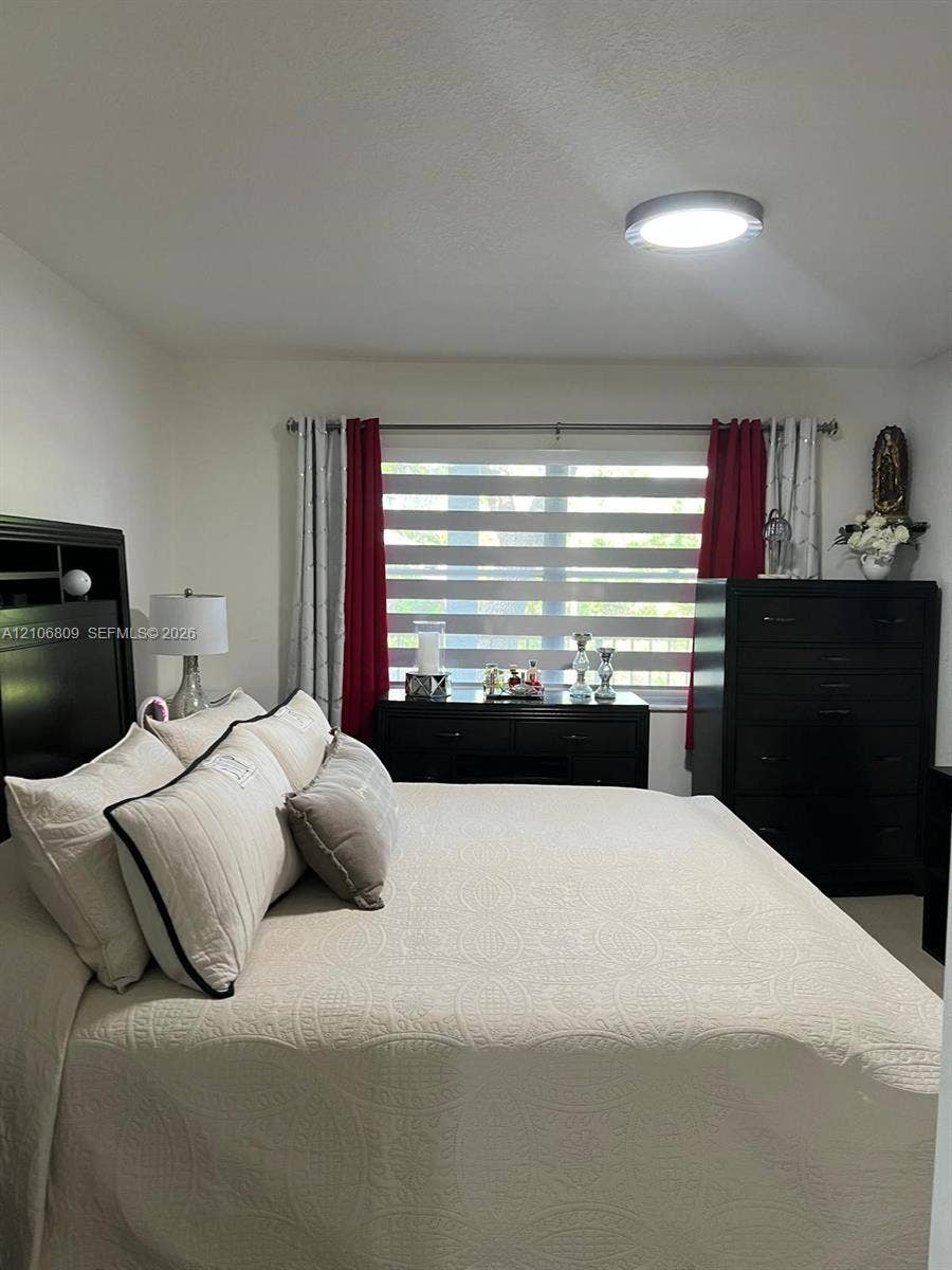12600 SW 5th Court, #204L, Pembroke Pines, FL 33027 Neutral wall color, dual-tone horizontal blinds, and a flush-mount overhead light fixture