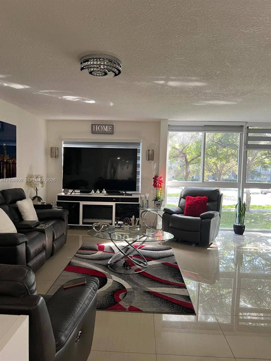 12600 SW 5th Court, #204L, Pembroke Pines, FL 33027 Polished tile flooring, floor-to-ceiling windows, and decorative chrome-finish flush mount lighting