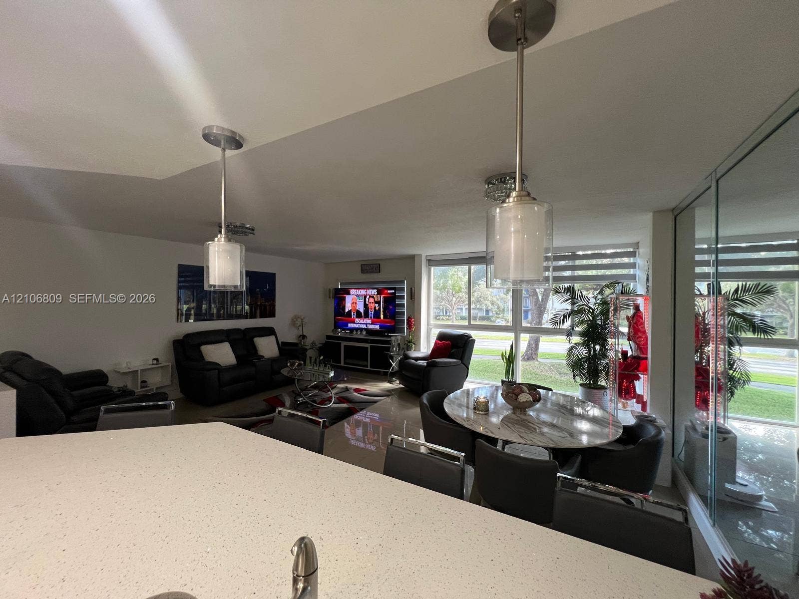 12600 SW 5th Court, #204L, Pembroke Pines, FL 33027 Quartz countertop with an integrated undermount sink, brushed nickel pendant lighting, high-gloss floor tile, and floor-to-ceiling windows