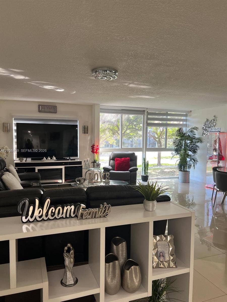 12600 SW 5th Court, #204L, Pembroke Pines, FL 33027 Living area featuring large-format tile flooring, floor-to-ceiling windows, and integrated wall lighting