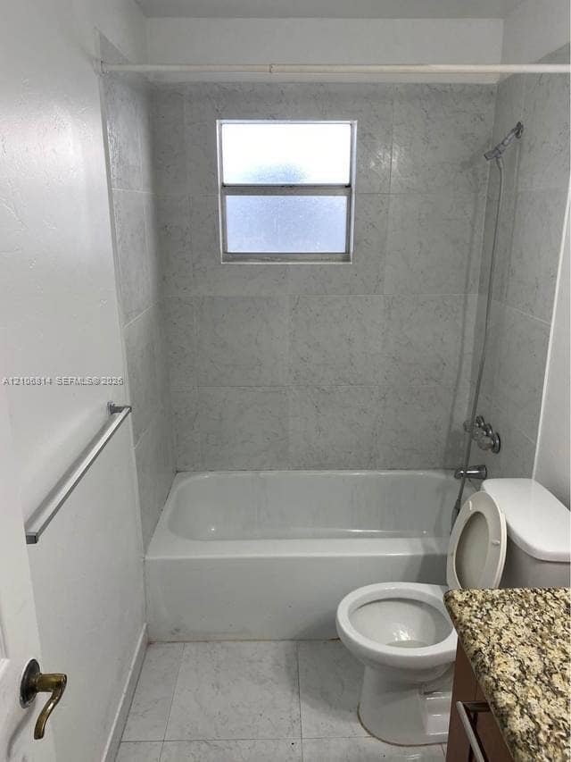 6503 Winfield Boulevard, #211AD, Margate, Margate, FL 33063 Bathroom featuring stone-finish countertop, tiled shower surround, integrated tub, and frosted window