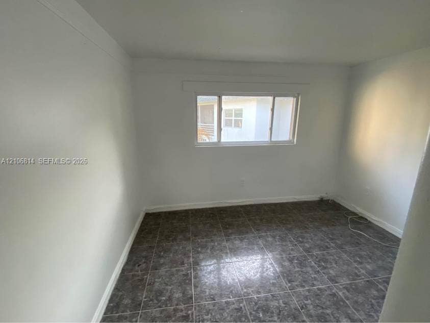 6503 Winfield Boulevard, #211AD, Margate, Margate, FL 33063 Neutral-toned interior space featuring stone-style tile flooring and a horizontal sliding window