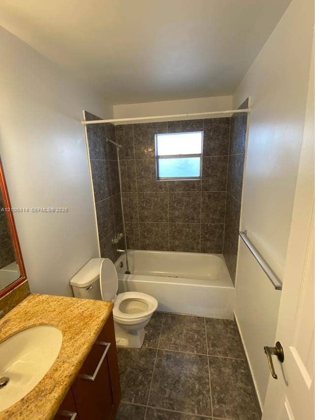 6503 Winfield Boulevard, #211AD, Margate, Margate, FL 33063 Bathroom featuring a stone-surface vanity with an integrated basin, tile-surround tub with an integrated shower fixture, and ceramic tile flooring