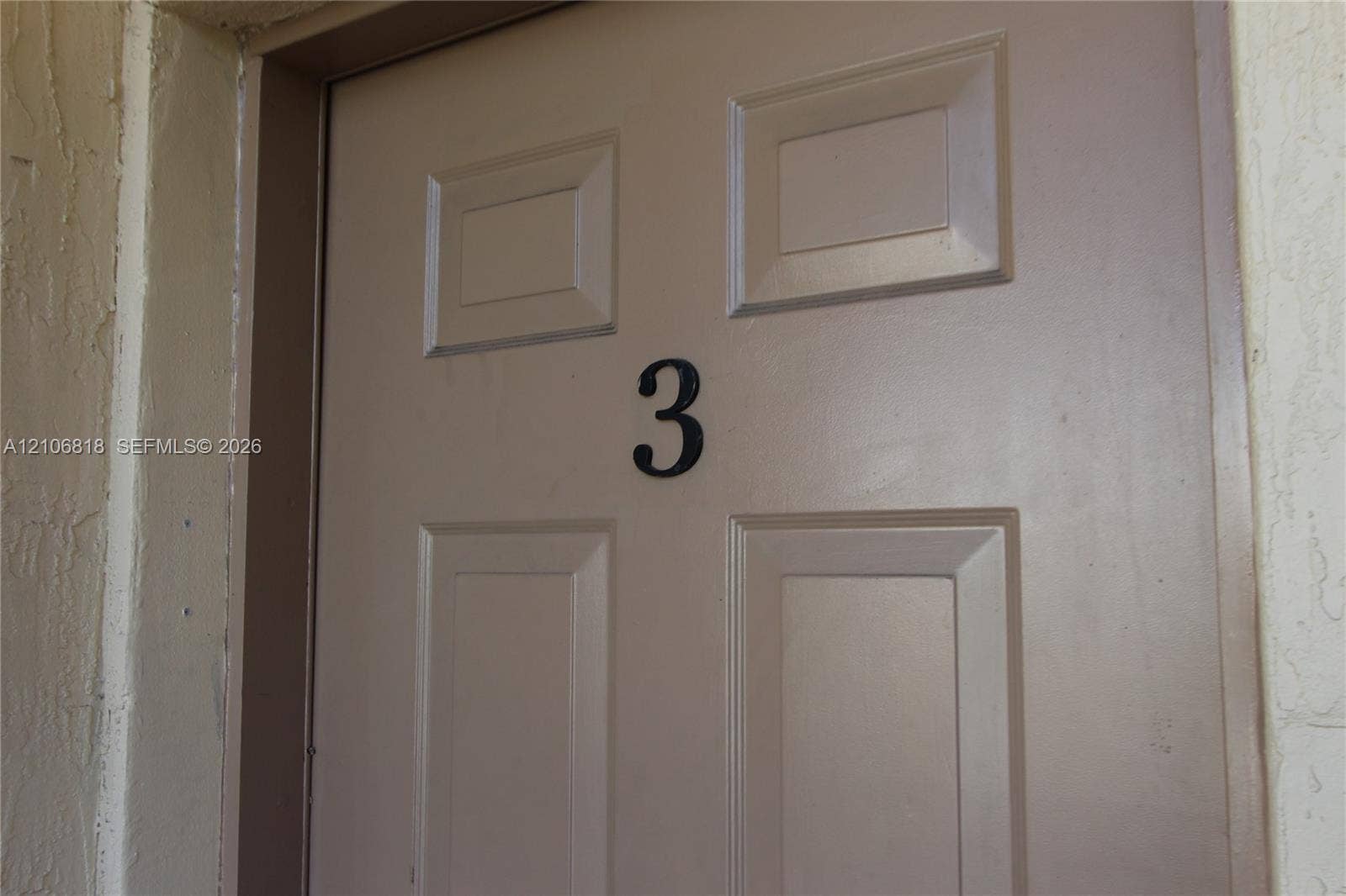 Four-panel entry door featuring a matte finish and a central numeral identifier