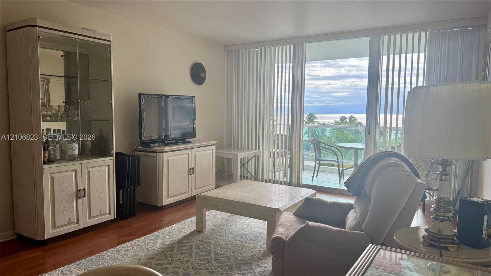 Living area featuring wood-finish flooring and floor-to-ceiling sliding glass doors providing outdoor access
