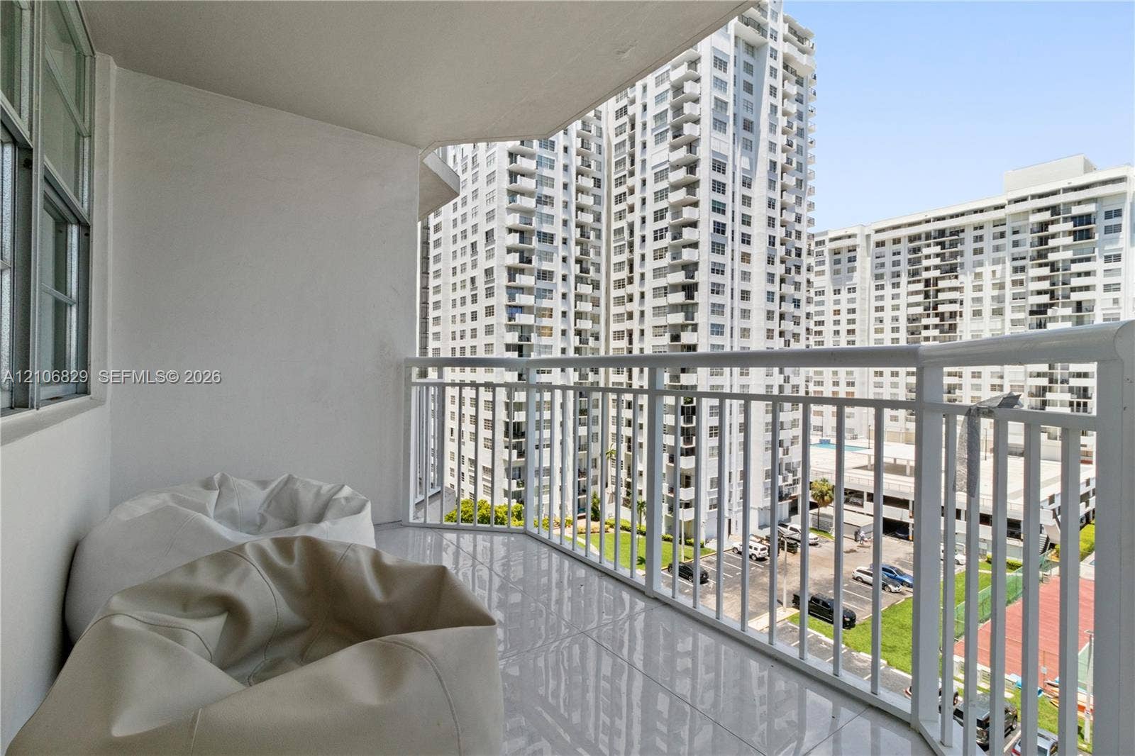 Covered balcony featuring tile flooring and a white metal railing