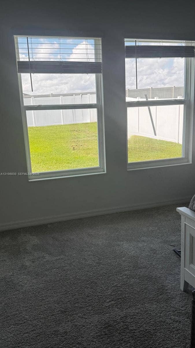 Dual energy-efficient windows, neutral wall coloring, textile flooring, and white vinyl perimeter fencing