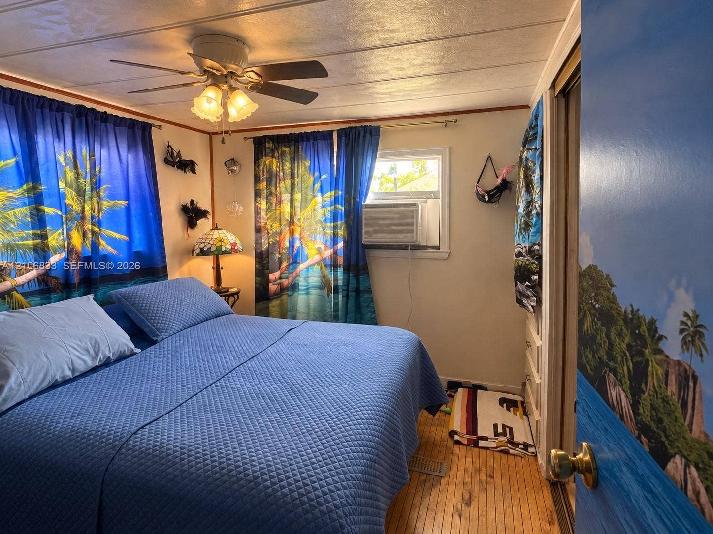 2782 E Marina Drive, Dania Beach, FL 33312 Room featuring wood-finish flooring, a ceiling fan with integrated lighting, and a wall-mounted air conditioning unit
