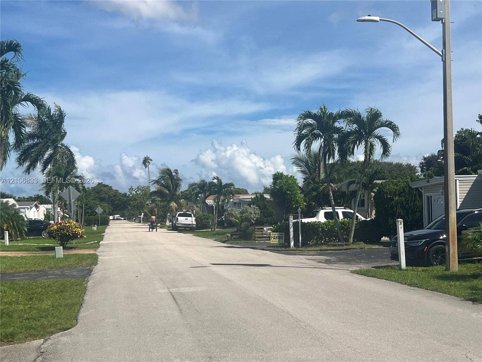 2782 E Marina Drive, Dania Beach, FL 33312 Paved street featuring mature palm trees, asphalt driveways, and overhead street lighting