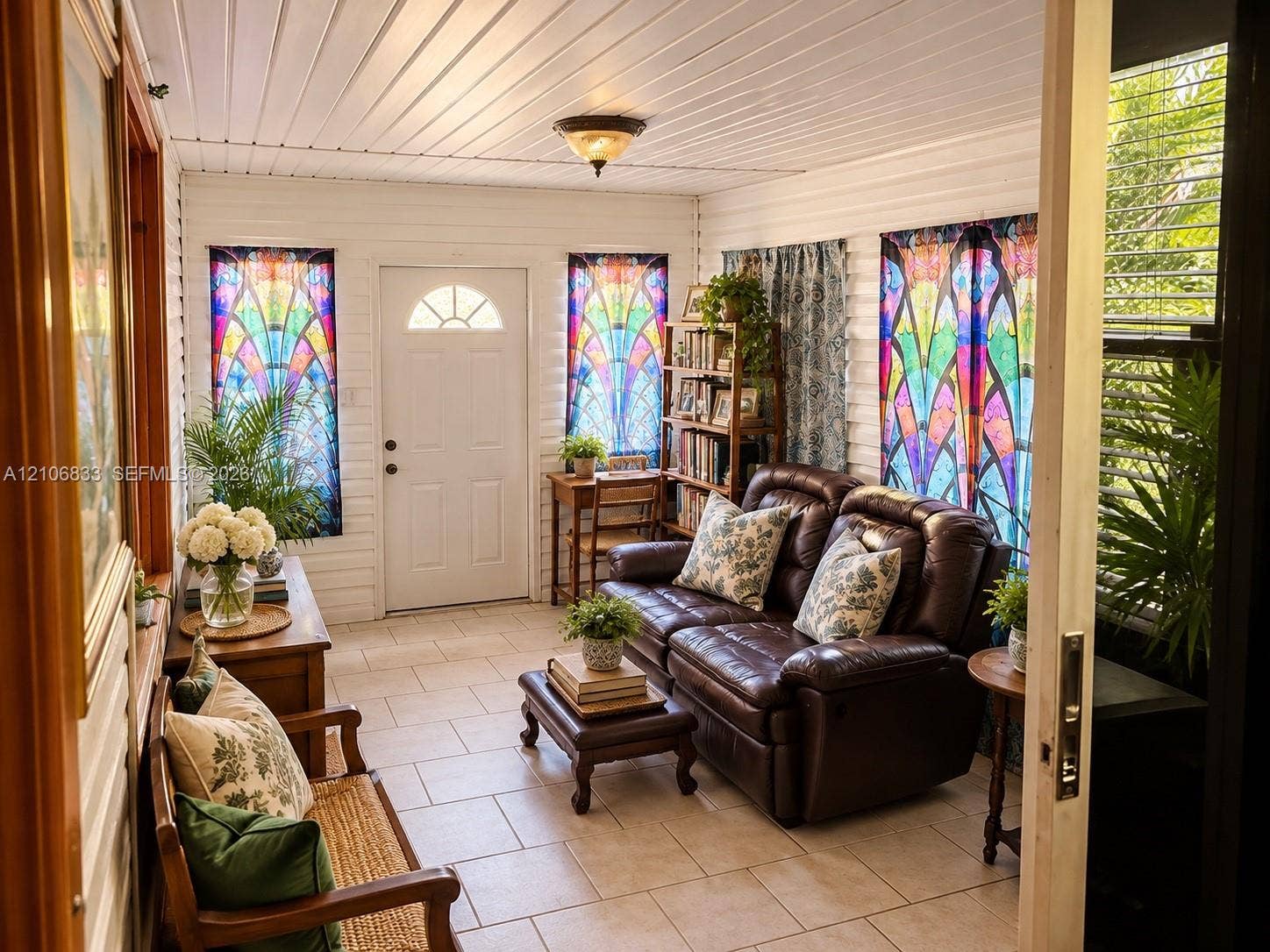 2782 E Marina Drive, Dania Beach, FL 33312 Sunroom featuring tile flooring, white horizontal wall paneling, a vaulted paneled ceiling, and a glass-paneled exterior door
