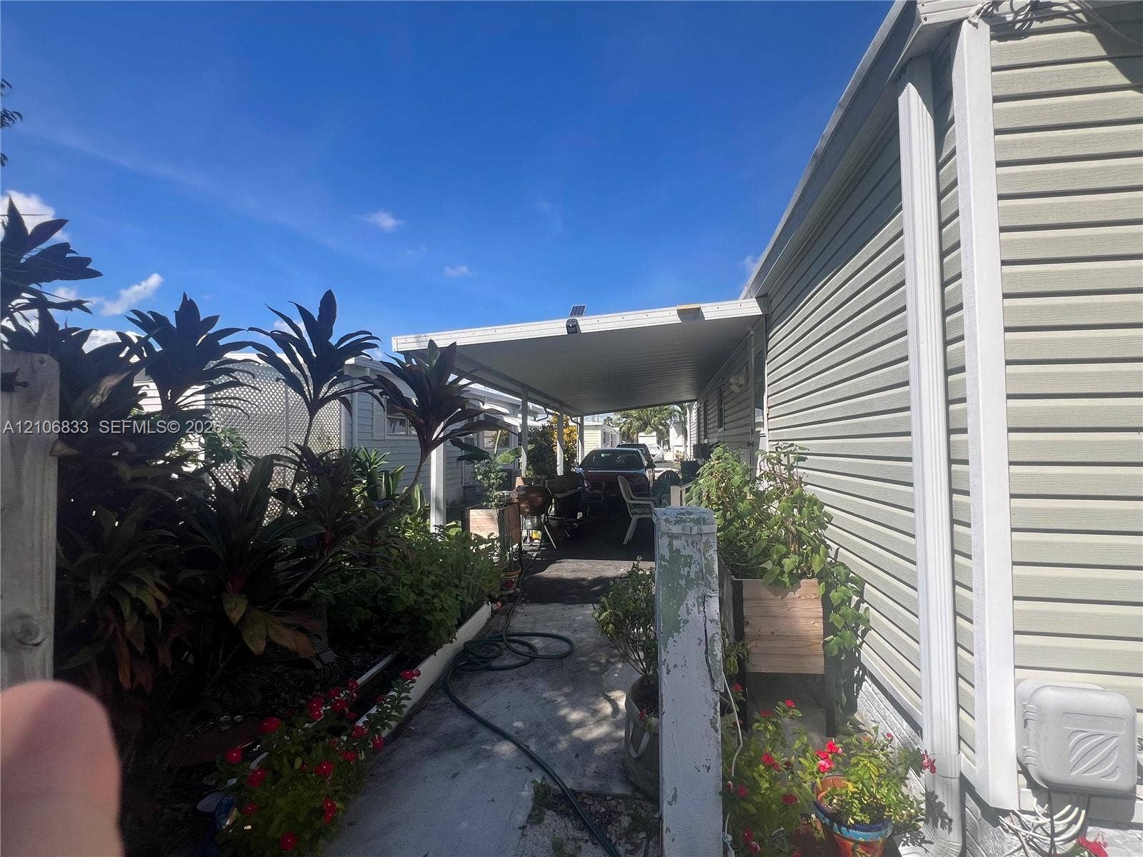 2782 E Marina Drive, Dania Beach, FL 33312 Horizontal vinyl siding exterior featuring a covered carport and paved driveway