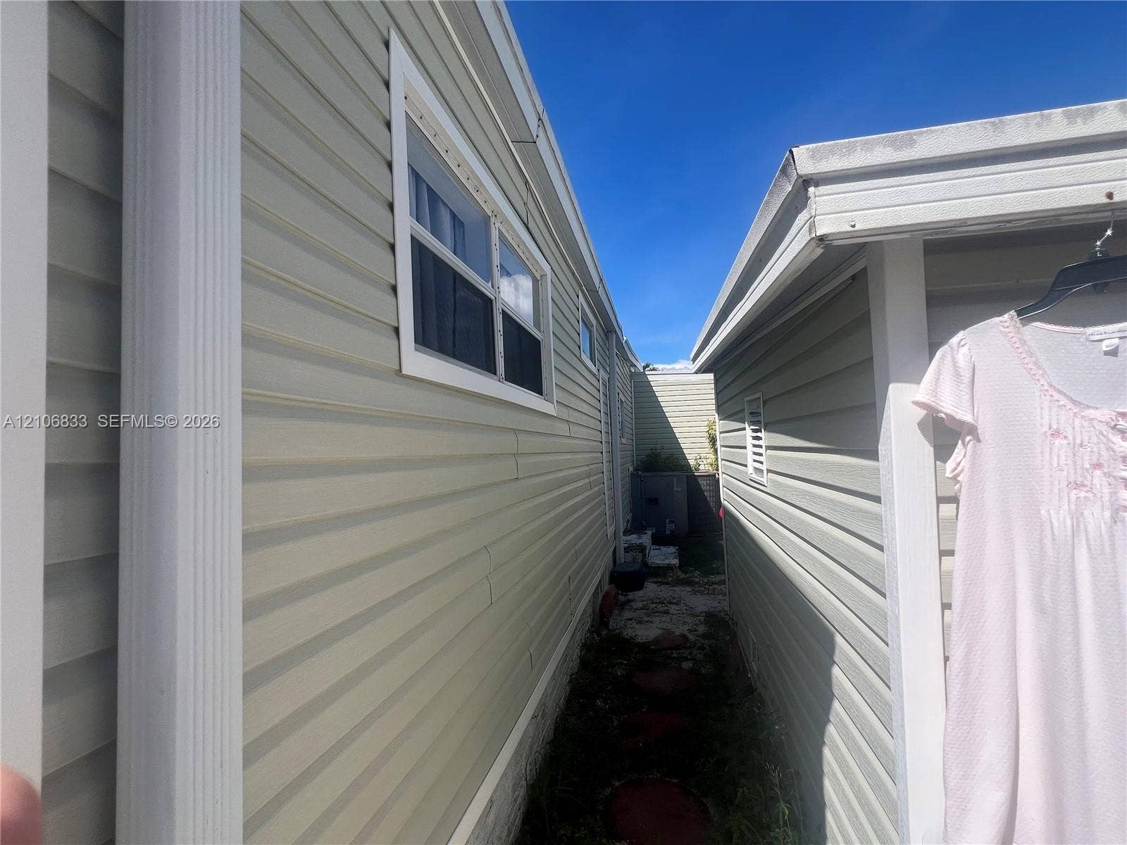 2782 E Marina Drive, Dania Beach, FL 33312 Vinyl horizontal siding exterior featuring white window trim, vertical corner molding, and integrated rain gutters