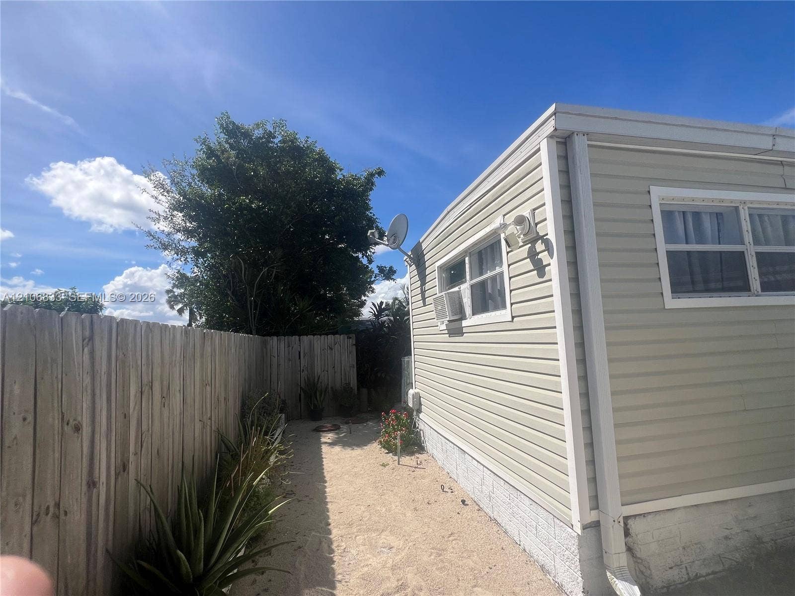 2782 E Marina Drive, Dania Beach, FL 33312 Exterior siding, wood-style privacy fencing, and a gravel ground surface