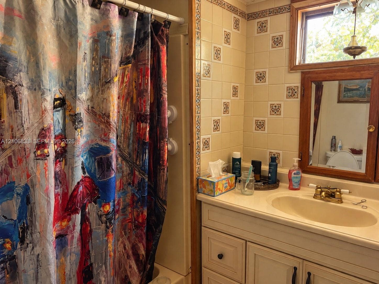 2782 E Marina Drive, Dania Beach, FL 33312 Bathroom featuring a white vanity cabinet with an integrated sink, a wood-framed medicine cabinet, and tiled wall accents