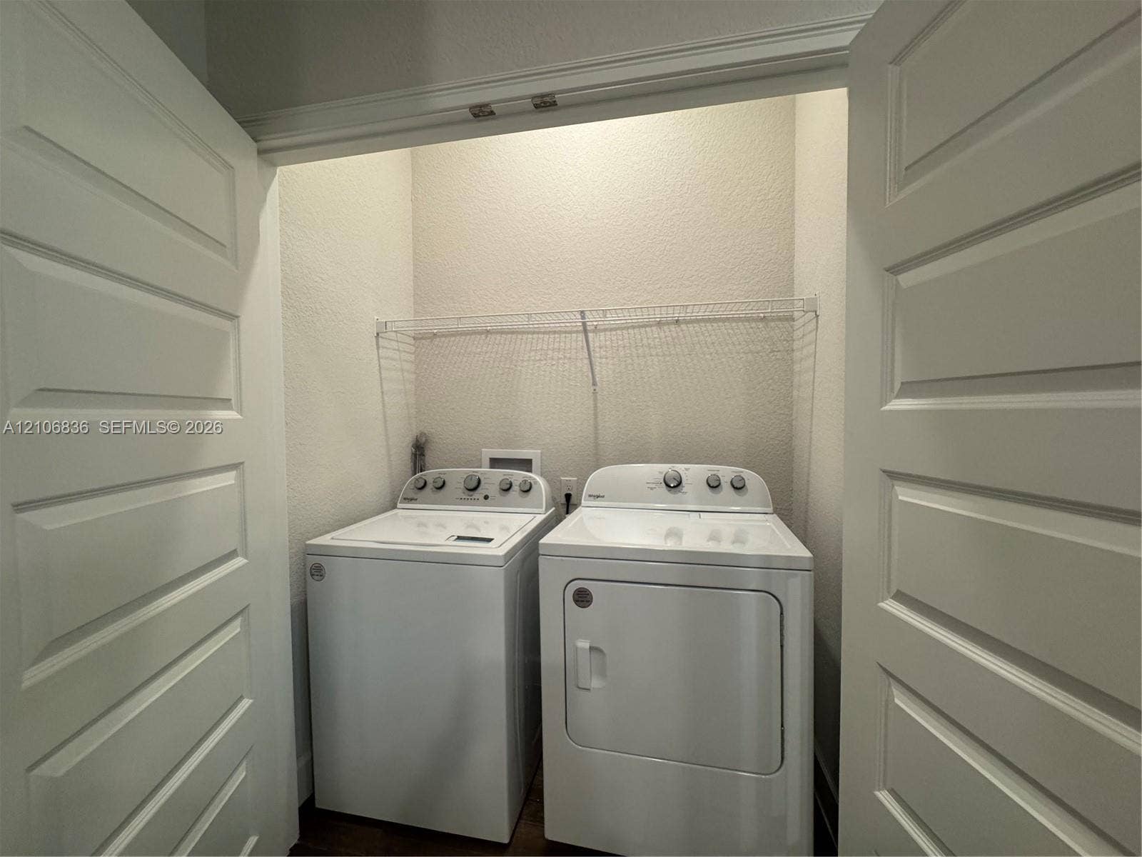 187 NW 45th Loop, Ocala, FL 34475 Laundry closet featuring dual panel doors and a wire storage shelf