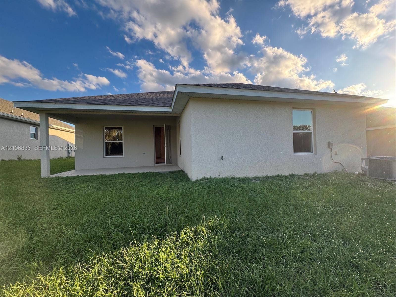 187 NW 45th Loop, Ocala, FL 34475 Stucco exterior featuring a covered rear patio, hip roofline, and clear-glass windows