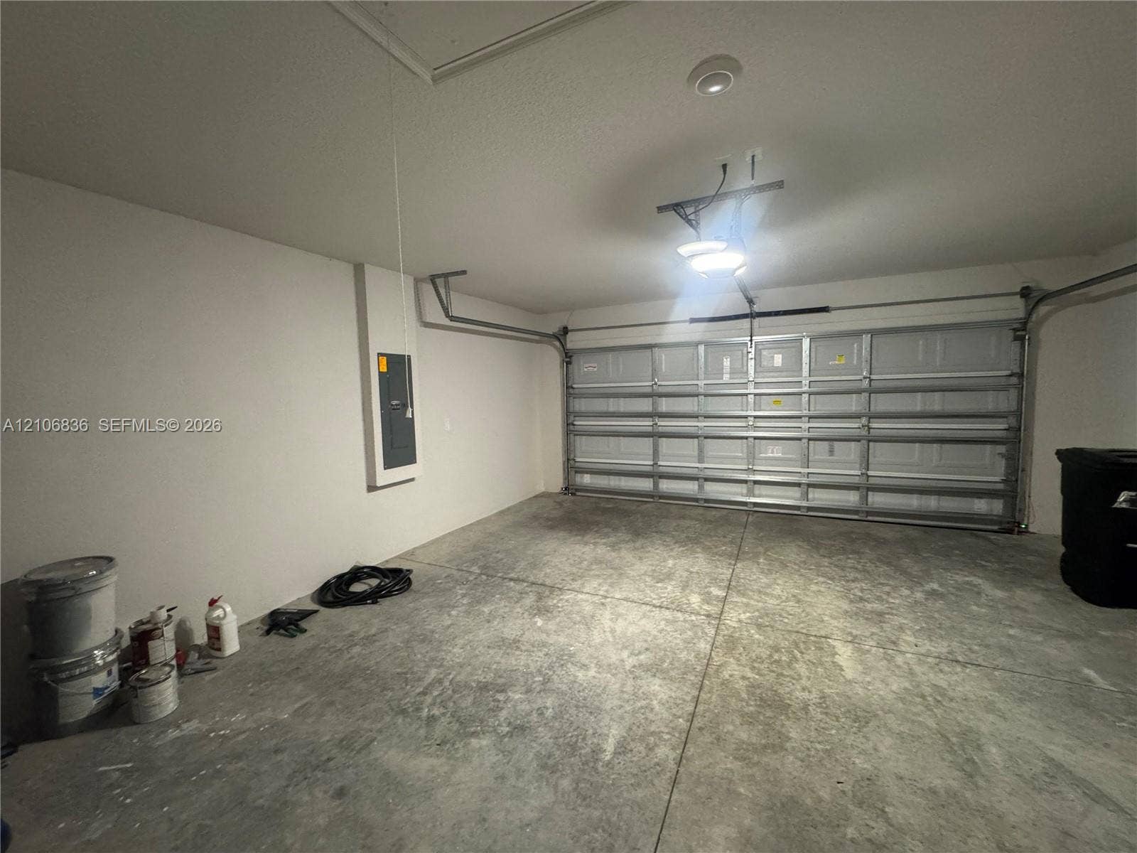 187 NW 45th Loop, Ocala, FL 34475 Two-car garage featuring a sectional overhead door, concrete flooring, and an integrated electrical panel