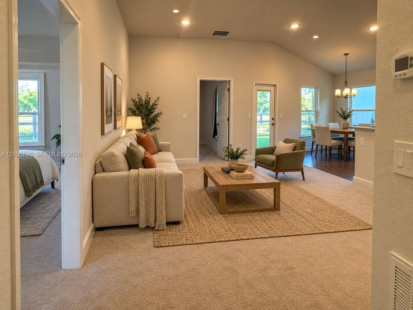 187 NW 45th Loop, Ocala, FL 34475 Open-concept interior featuring vaulted ceilings, recessed lighting, neutral carpeting, and a glass-paneled exterior door